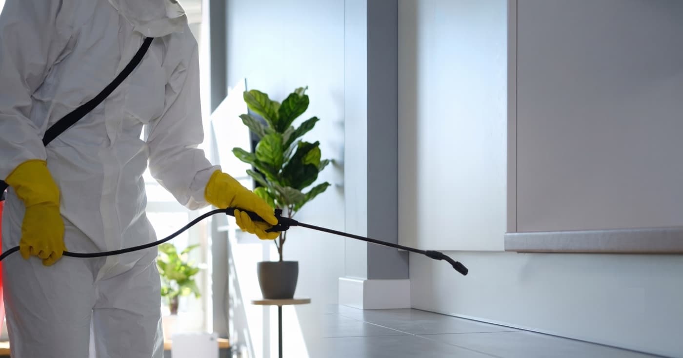 Pest control technician treating a home interior.